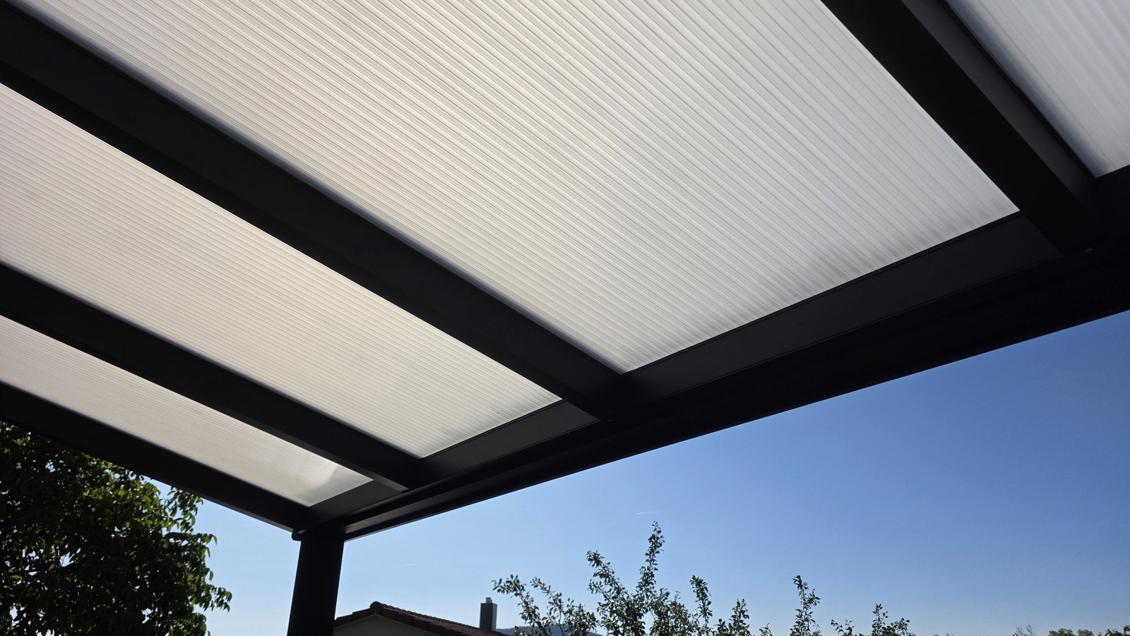 Doppelstegplatten und Aluminium-Sparren von unten gegen den Himmel